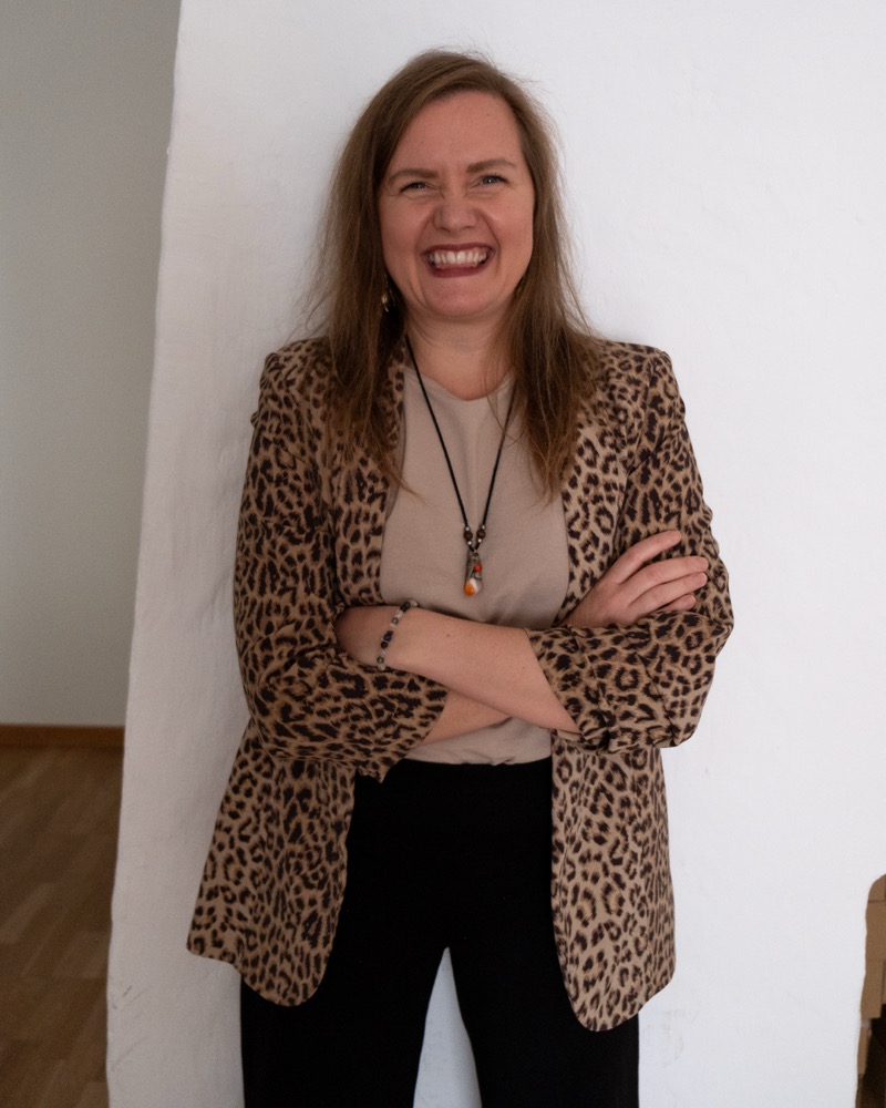 Annelie Näs laughing with her arms crossed, wearing a leopard-print jacket