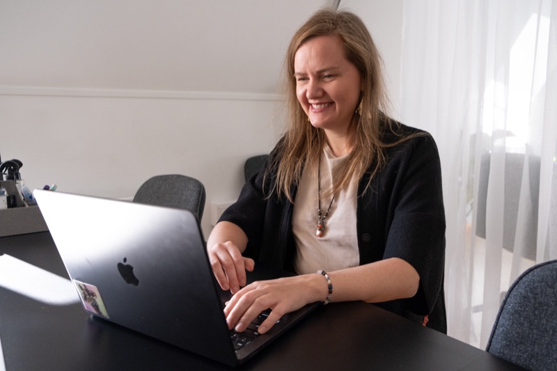 Annelie Näs smiling at her laptop during an online conversation