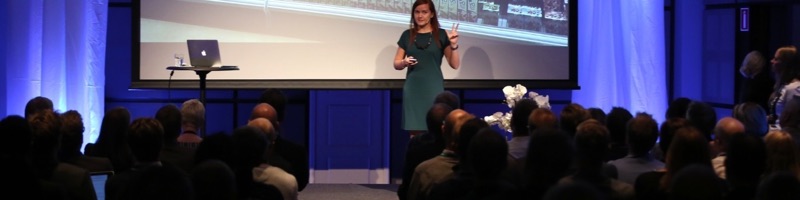 Annelie Näs speaking on a stage in front of a full audience